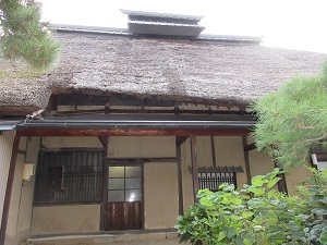 茅葺き屋根のある、古風な建物の外観の写真