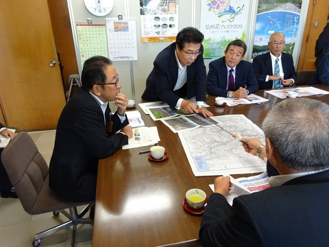 市長と関係者一同が机に地図を並べて話し合っている写真