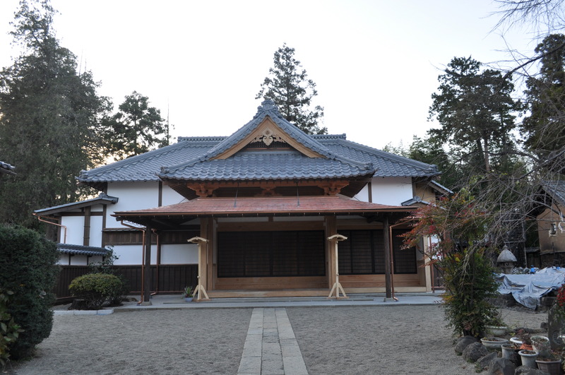 森林内にある青い屋根と茶色い柱の歴史的建造物