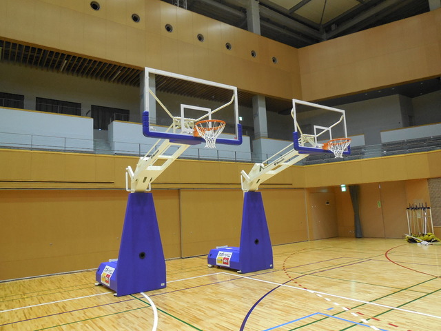 2台横に並んでいる青と白で着色されたバスケットゴールを、斜め前から撮影した写真