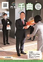 スーツを着た男性が笑顔で花束を受け取っている、2020年12月号の市報表紙