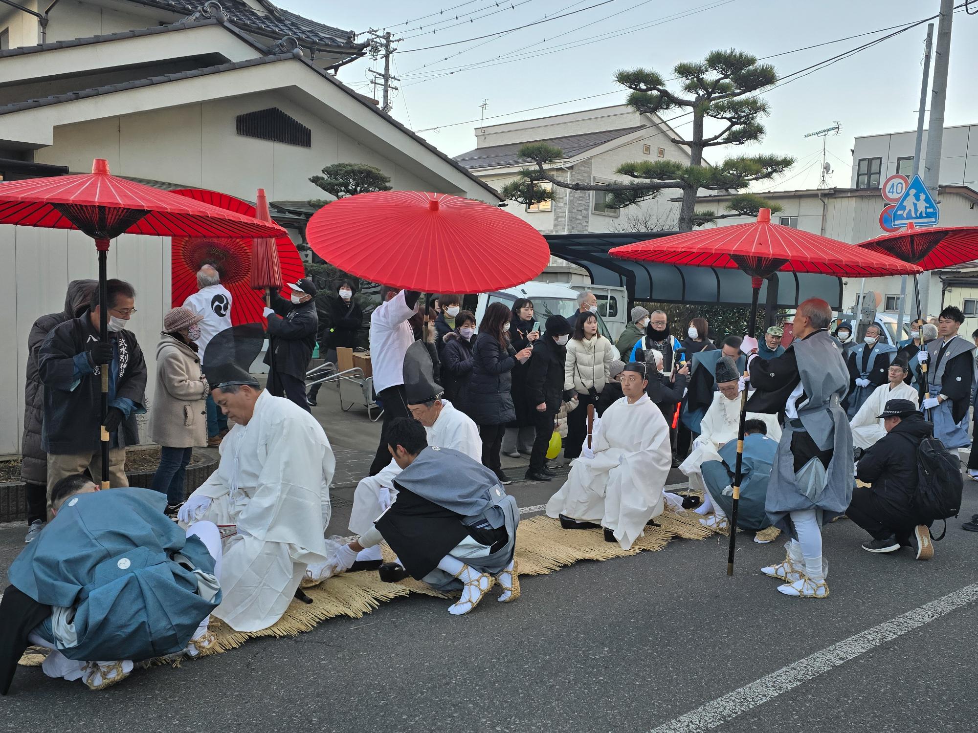 大頭祭で、頭人たちが神社に入る前に靴を履き替えている様子の写真