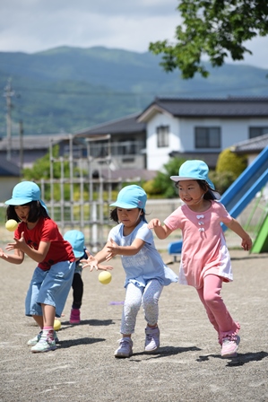 キャッチボールをする青い帽子の園児3人が移った写真