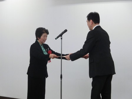 代表の女性へ表彰状が手渡される瞬間の写真