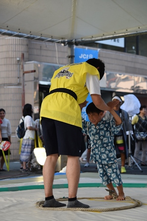 こどもと手押し相撲を楽しむ大人スタッフの写真