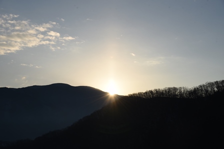 古墳から山々の向こうに臨む初日の出の写真