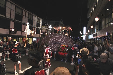 夏祭りの夜に大きな獅子舞が道の真ん中で舞っている写真