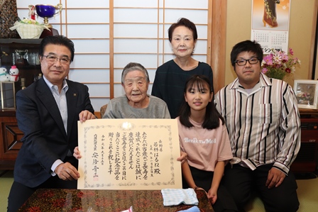 表彰状を受け取った若林はる江さんご家族と市長が記念撮影をしている写真