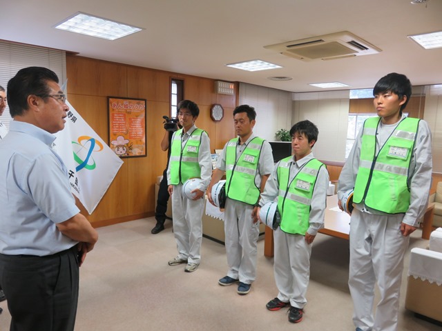 黄緑のチョッキを着た土木技術職員を派遣するために市長が激励式を開いている写真