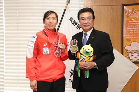 獲得したメダルを持った女子ハンドボール選手とマスコットのぬいぐるみを持った市長の写真