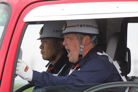 消防車に乗っている消防員二人の写真
