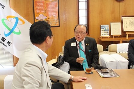 会議室で座って話をする年配の男性二人の写真