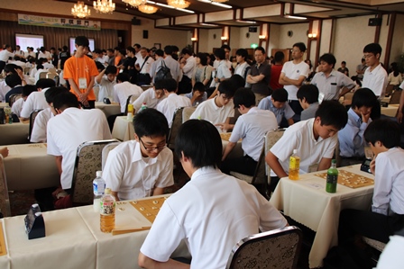 ホテルの広間で高校生何組もが将棋をしている写真