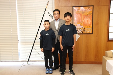 小学6年生の男の子二人が市長と三人で並んでいる写真