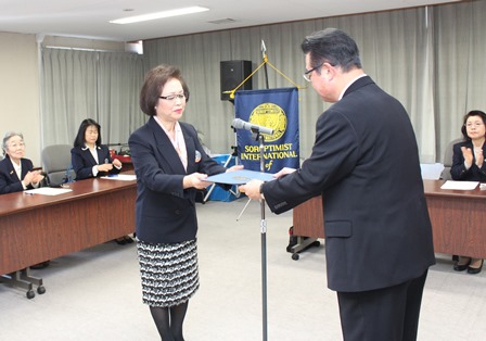 スーツ姿の大西富佐恵会長から目録を受け取る市長の写真