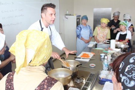調理室でハンガリーの料理を参加者たちに教えるラーツさんの写真