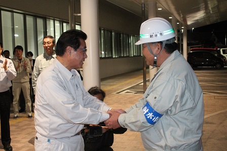 作業服を着た班長が市長と握手を交わす写真