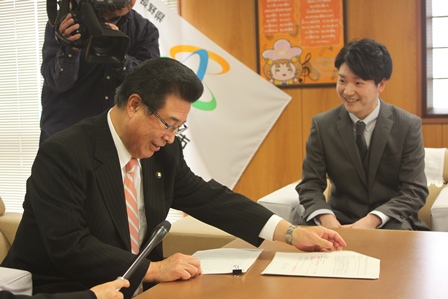 笑顔で対談する岡田市長と塚田浩司さんの写真