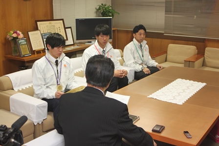 ソファに腰掛け、岡田市長と対談をする入賞者の男性3人の写真