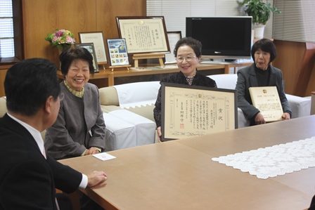 受け取った表彰状を持ちながら、岡田師匠と談話する女性3人の写真