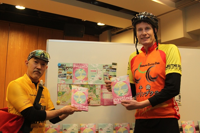 パンフレットを持ってサイクリングマップを紹介している男性二人の写真