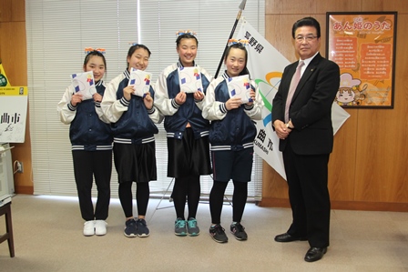 市長の隣に並び記念品を受け取って笑顔の女の子4人の写真
