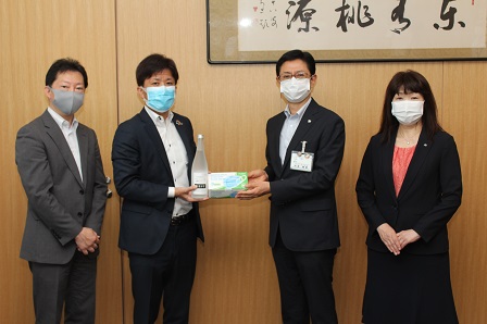 マスクを付けた市長と第一生命保険株式会社の皆さんがカメラのほうへ寄贈品を見せながら立っている写真
