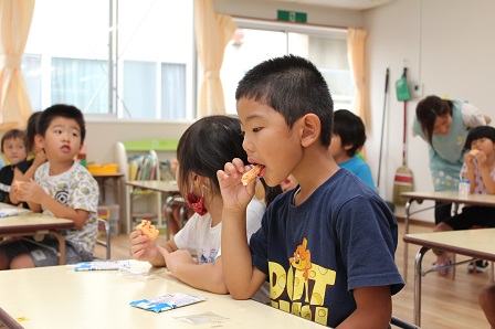 あんずのお菓子をおいしそうに食べている園児たちの写真