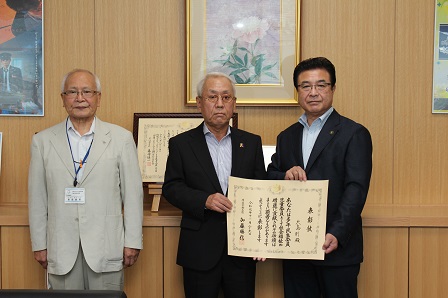 表彰状を手に持ち記念撮影をしている市長と会長、前会長の写真