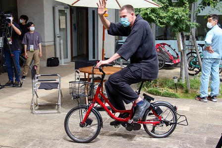 赤い自転車に乗ったタイラーさんの写真