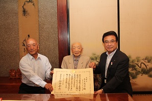 表彰状を受け取った青木茂子さんとご家族の写真