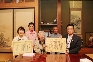 表彰状を受け取った北澤光子さんとご家族の写真