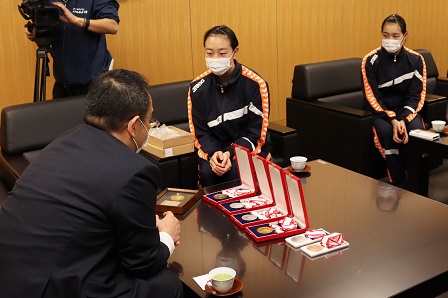 ソファに座り、メダルを見せながら市長とお話している和田姉妹の写真