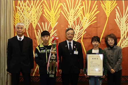 トロウィーや表彰状を手に持ち記念撮影をする吉川部長、緑川副部長の写真
