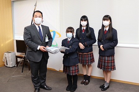 屋代南高校の女子生徒三名が市長に楽らくねまきを手渡している写真