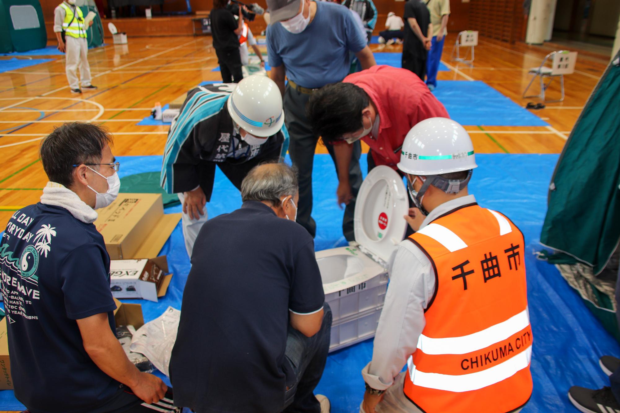 市職員に避難所設営方法の説明を受ける市民