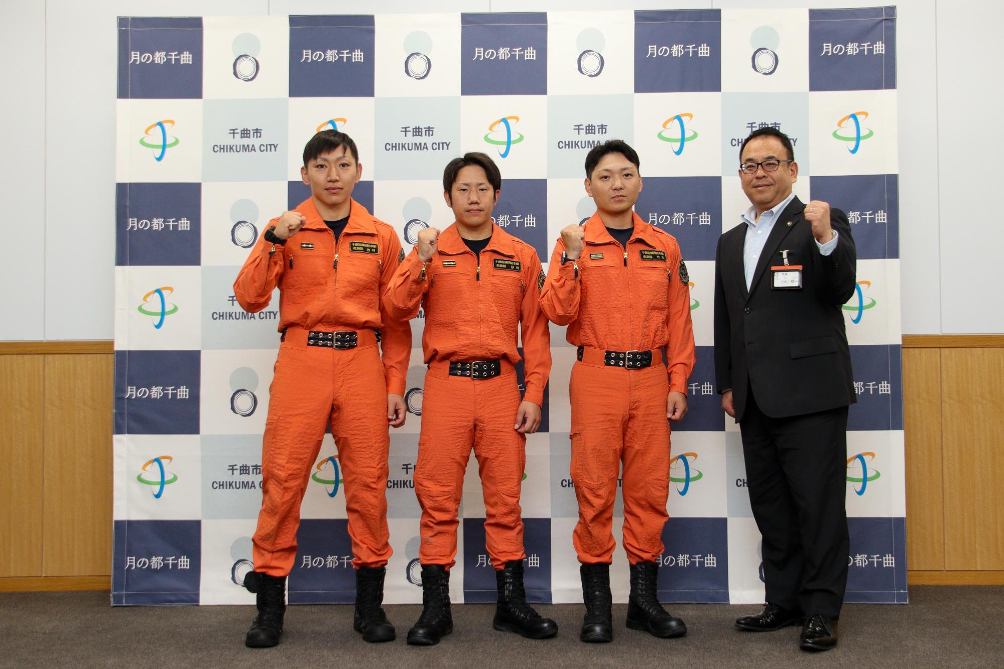 ガッツポーズをする、ほふく救出に出場する救助隊員3名（左から西村隊員、砂川隊員、竹本隊員）と小川市長（一番右）