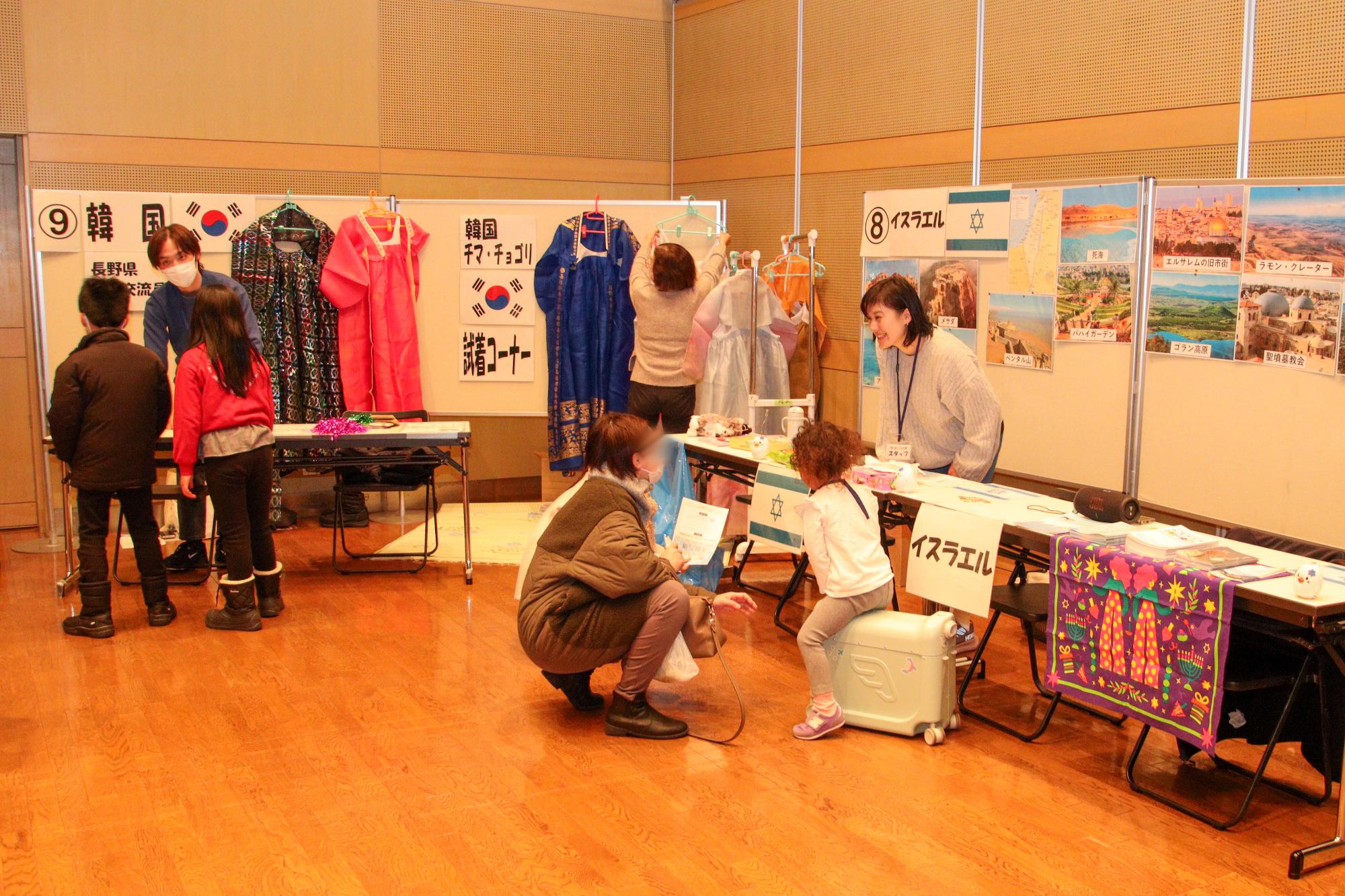 韓国ブース（左）、イスラエルブース（右）を見学する来場者たち