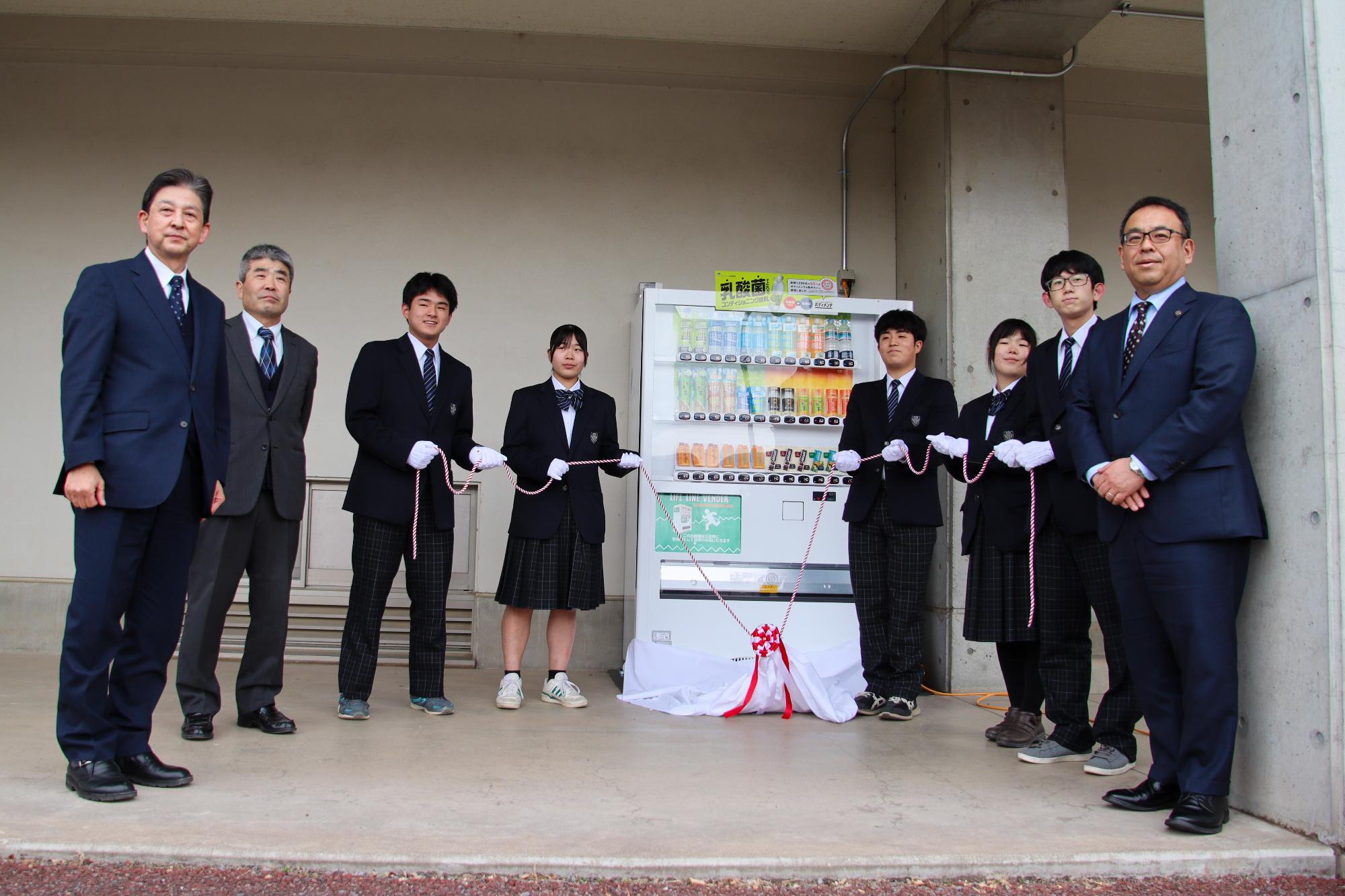 自動販売機除幕式後の記念撮影（右から小川市長、屋代中学校生徒5名、柳澤校長先生、、蟹澤教育長）