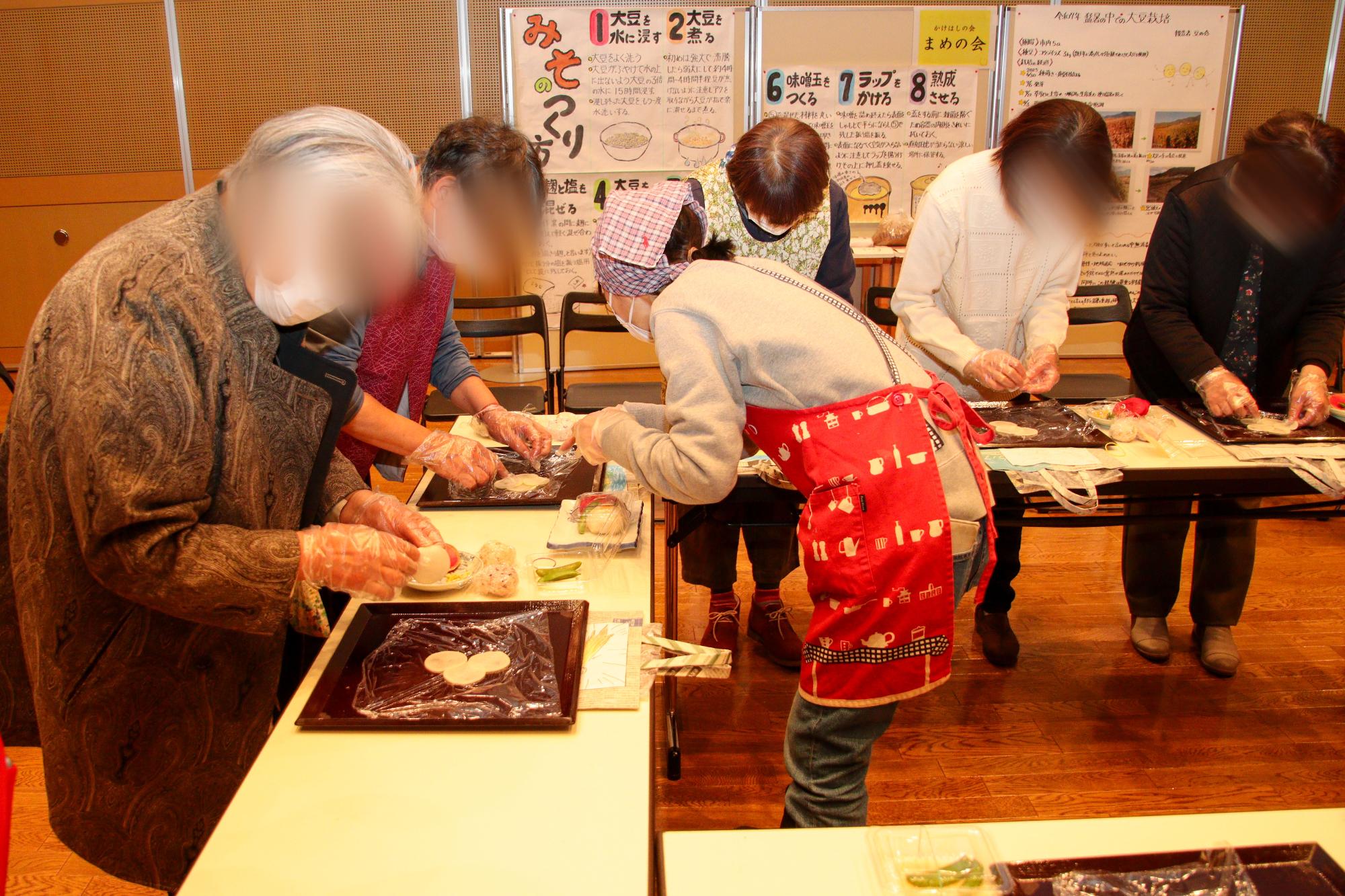 椿寿司づくりを体験する参加者と作り方を教えているかけはしの会会員
