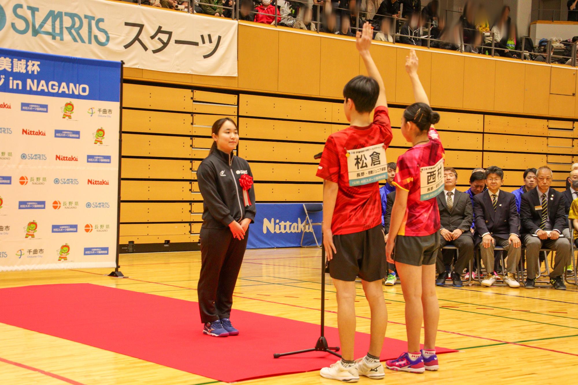選手宣誓をする選手2名（右）とそれを受ける伊藤大会名誉会長