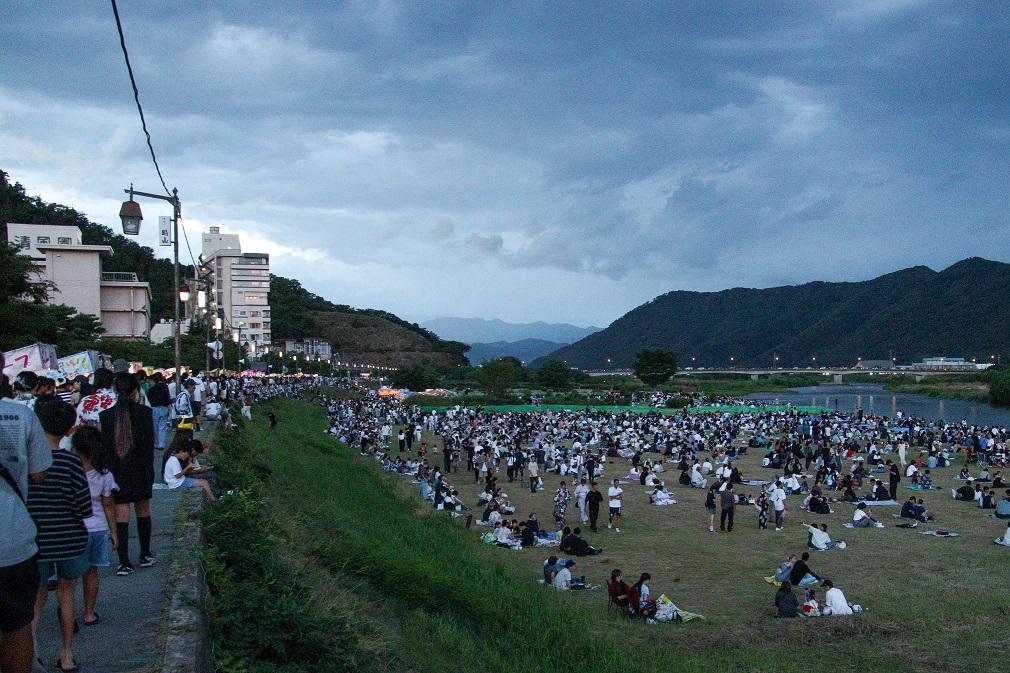 花火を見ようと千曲川河川敷に多くの観客が訪れている様子