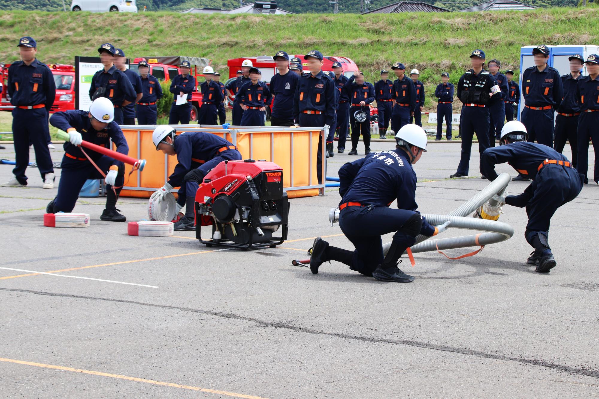 小型ポンプ操法で、水利の確保やホースの接続を行なう様子