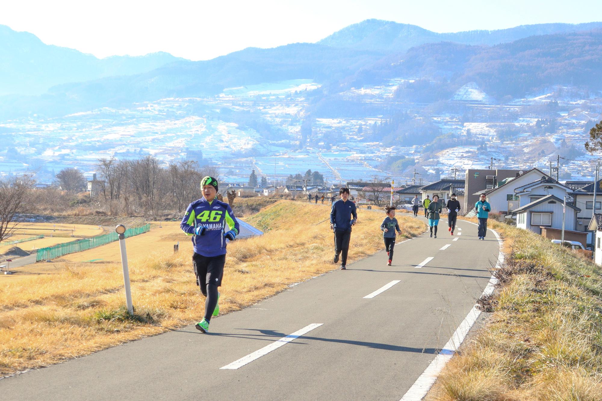 元旦マラソンで堤防道路を走る市民