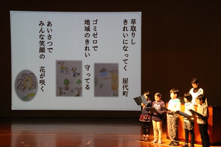ステージで作品を発表する小学4年生5名の写真