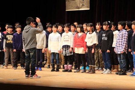 ステージで合唱する小学6年生の写真
