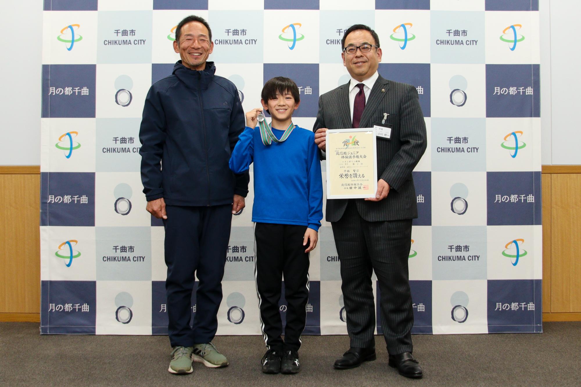 コーチ（左）と平林さん（中央）、小川市長（右）で記念撮影をしている様子