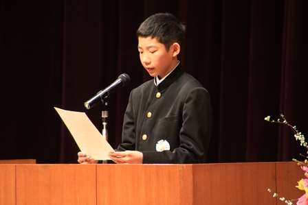 ステージでスピーチする中学校2年の男子学生の写真