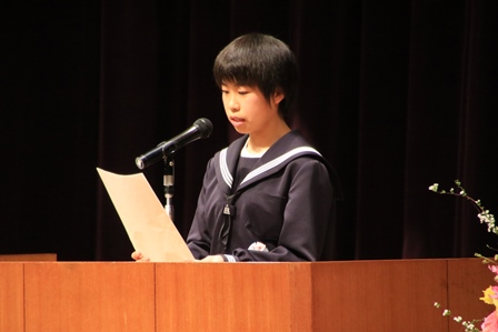 ステージでスピーチする中学校2年の女子学生の写真