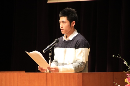ステージでスピーチする高校2年の男子学生の写真